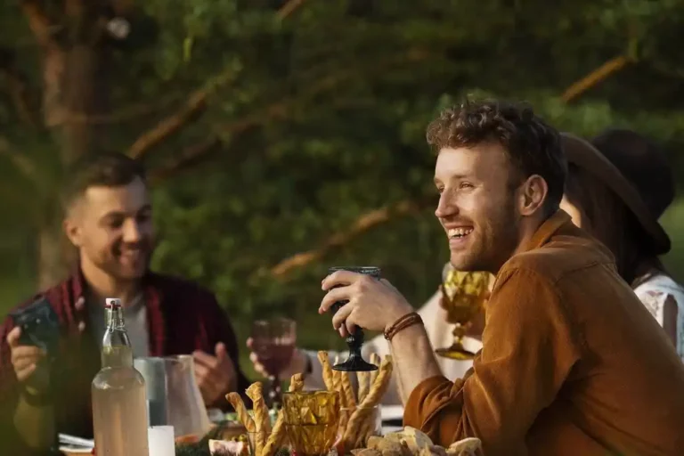 Parejas disfrutando de una comida al aire libre en un restaurante de El Albir con palmeras y vistas al mar Mediterráneo