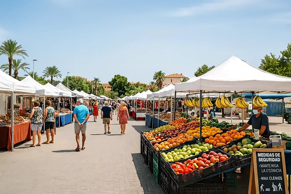 Albir Street Market with stalls of fresh fruits, vegetables, and local products on a sunny day.