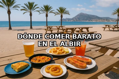 Picnic en la playa del Albir con menú barato: paella, tortilla, pan y bebidas sobre mesa de madera con vistas al Mediterráneo.