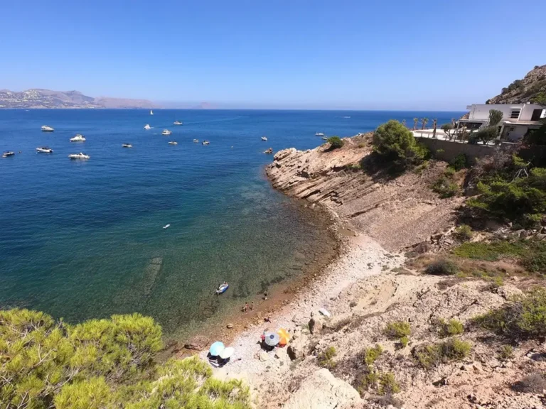 Vista panorámica de la Cala del Amerador en El Albir con aguas cristalinas y entorno rocoso del Parque Natural Serra Gelada.