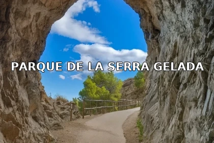 Túnel en la ruta al Faro del Albir dentro del Parque Natural de la Serra Gelada, con el camino curvado y el cielo azul enmarcado por la roca.