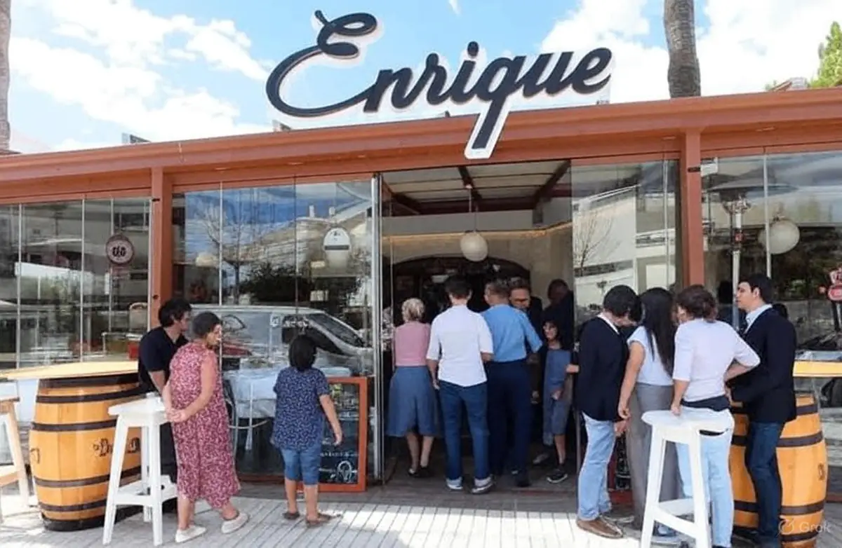 gente esperando mesa con copas de vino y cervezas en la entrada del Restaurante Enrique El Albir 2025