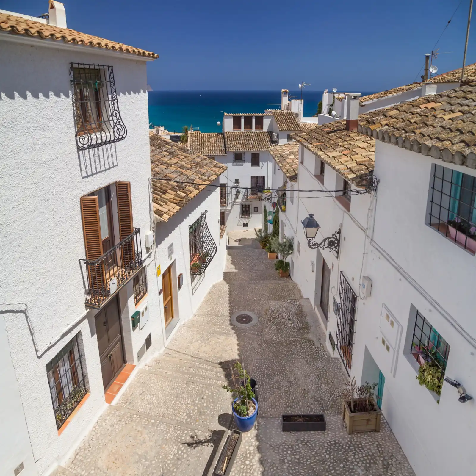 Calle del casco antiguo de Altea con casas blancas y vistas al mar Mediterráneo